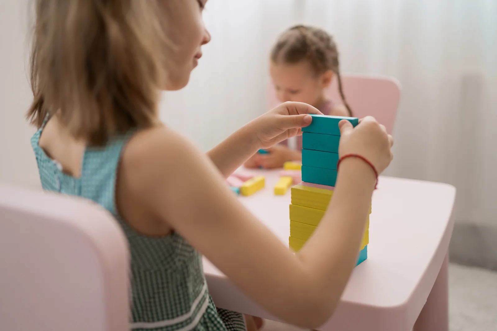 Niñas jugando con bloques de madera de colores
